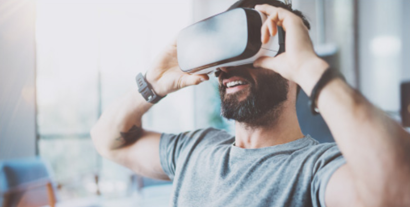 Young man with beard wearing a virtual reality headset.
